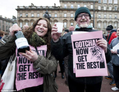 British left celebrants holding champagne and leaflets reading 'GOTCHA! Now get the rest'