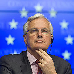 Michel Barnier, with a background of the European Union's flag's stars appearing as a halo