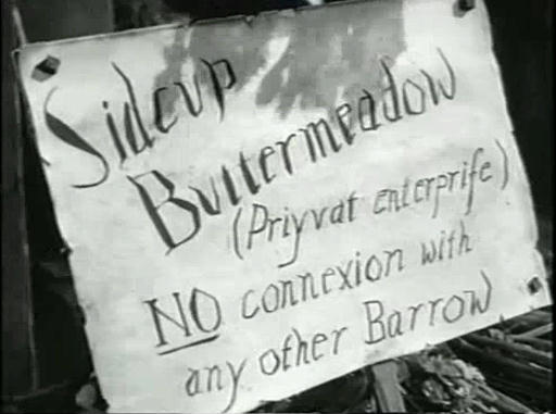 Capture from Cardboard Cavalier (Walter Forde, 1949), Sidcup Buttermeadow's (Sid Field) barrow placard: Sidcup/ Buttermeadow/ (Private Enterprise)/ NO connexion with/ any other Barrow