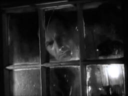 Capture from The Phantom Light (Michael Powell, 1935); a man holding a lantern and looking out of the window