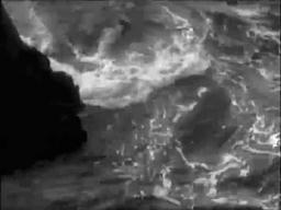 Capture from The Phantom Light (Michael Powell, 1935); swirling and breaking waves on a small area of rocky shore, seen from above
