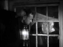 Capture from The Phantom Light (Michael Powell, 1935); a man outside, holding a lantern, and another man inside, looking at each other through a window
